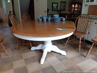 Front view of table showing oval top and painted pedestal base
