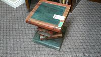 Top-down angled view showing the book-themed stool with textured pages and green cover top