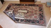 Large carpet with corner folded showing floral medallion design