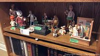 Wooden shelf with assorted medical and humorous figurines including animals and humans in doctor-patient scenarios
