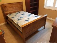 Assembled bed frame with mattress in bedroom corner
