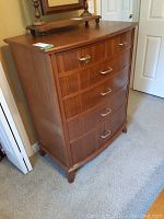 Front and side view of a wood dresser with a bowed front and 6 drawers.