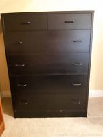 Front view of the black dresser showing all six drawers closed.