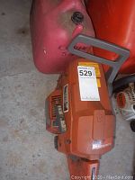 Husqvarna chainsaw body with part of chain and blade cover, showing overall condition and brand labels.
