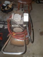 Front view of compressor with hoses coiled around handle