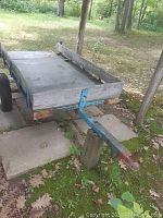 Front side view of trailer showing wooden deck and metal drawbar