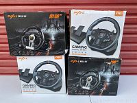 Four PXN wheel boxes, two black V3 Pro and two white V900, stacked against red door