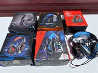 Overview of five boxed headsets and one unboxed headset on a table