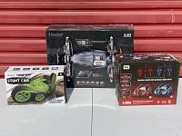 Three boxed remote control cars sitting side by side on a white surface.