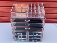 Clear acrylic makeup organizer set with three pieces stacked showing drawers and compartments