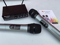 Full view of two microphones, receiver unit, and user manual on white surface.