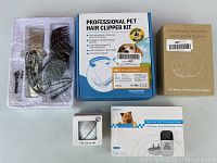 Photo showing sealed pet hair clipper kit box, GPS wireless pet fencing system box, and small white box for USB cat toy ball.