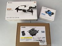 Three drone boxes: Eachine E511, Snaptain SP350, Zuhafa Double Position Photo