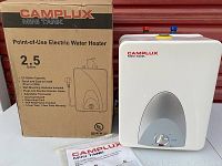 Camplux Mini Tank electric water heater with original box showing 2.5 gallon capacity and key features including adjustable thermostat and mounting hardware.