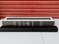 Black soundbar placed in front of its original box labeled 'ODINE II 2.0CH SOUNDBAR SYSTEM'.