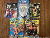 Wide shot showing five wrestling figures in original packaging on wooden surface.