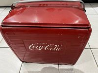 Front view showing Coca Cola logo on red metal cooler.