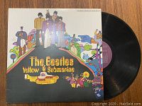 Front cover of The Beatles Yellow Submarine vinyl record showing colorful cartoon artwork with the four band members and yellow submarine.