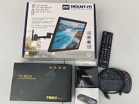 Full view of the Mount-IT! TV Mount box, T95Z Plus TV box, Wechip Air Mouse box, and a remote control on a white surface.