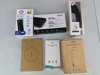 Top-down photo showing all boxed items: Samsung screen protector, wireless charger, Taurus power bank, phone case, phone stand, and handset phone accessory.