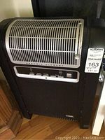 Full view of the black ceramic element ionic heater with metal grille and control panel showing buttons and power switch. Brand Lakewood visible.