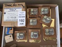 Lot of nine vintage mechanical musical box movements mounted on wooden plaques, visible metal combs and cylinders inside clear casing, in original Norcold, Inc. cardboard box