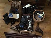 Overview of the lot showing shelves, plate stands, basket with plaque stand, boxed plaques, and small wooden pieces