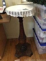 Full view of wooden stand table with white crochet doily