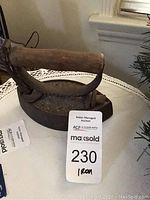 Photo of antique iron showing wooden handle attached