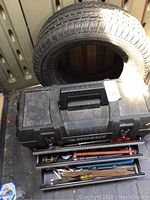 Overview of closed Husky toolbox in vehicle trunk with spare tire behind it