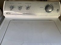 Top control panel of the Maytag washing machine showing dials for water level, extra rinse, wash/rinse temp, and cycle types including Delicates to Regular.