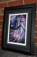 Full view of the framed and matted "Moon Dancer" print leaning against a brick wall, showing the overall condition and frame style.