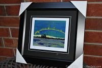 Framed and matted "Northern Lights" print by Tom Thomson with black and white mats and metallic frame, showing the overall presentation of the art piece.