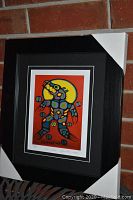 Front view of the framed "Medicine Bear" print displaying the artwork, matting, and black frame with protective corner covers.