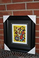 Framed art print with protective corners on frame edges, showing abstract vibrant colorful image.