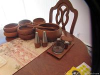 Full set arranged on dining table: bowls, servers, tall shakers, tray components