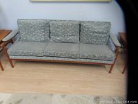 Full front view of three-seat sofa on wood floor