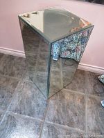 Full view of the rectangular mirrored pedestal showing reflective glass surfaces on all sides and beveled tops.