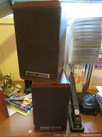 Pair of Koss M/60 Plus speakers stacked on each other showing wood cabinet and fabric front