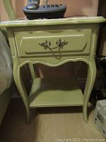 Single side table shown with drawer closed, lamp and phone on top, illustrating French Provincial styling.