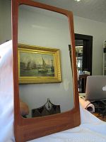 Full view of the vintage mirror showing teak frame and clear reflective surface
