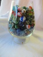 Full view of glass bowl filled with assorted marbles showing a variety of colors and sizes.