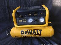 Front view of yellow DEWALT air compressor showing dual pressure gauges, regulator knob, and handle frame