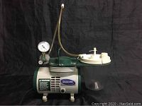 Full view of the Ashcroft Medigas 258680 compressor unit with collection jar and pressure gauge attached.