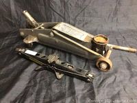 View showing hydraulic floor jack and mechanical scissor jack side by side to show scale and condition.