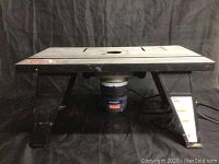 Side view of Ryobi RT101 router table showing table surface and electrical component underneath.