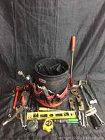 Full lot view showing bucket and array of hand tools on black fabric background