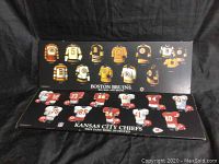 Both wooden plaques showing Boston Bruins and Kansas City Chiefs jerseys and helmets on black backgrounds with respective team logos and slogans.