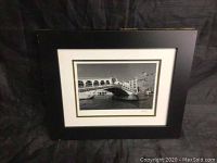 Front view of framed black and white photo showing gondola passing under the Rialto Bridge in Venice by Jesse Kalisher.