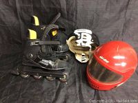 Image showing the pair of Koho 3500 inline roller blades alongside the black and white Cooper hockey helmet and the red Ski-Doo full-face helmet.